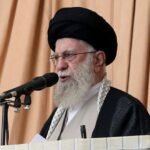 Iran’s supreme leader holds rifle as he issues warning about possible future missile attack