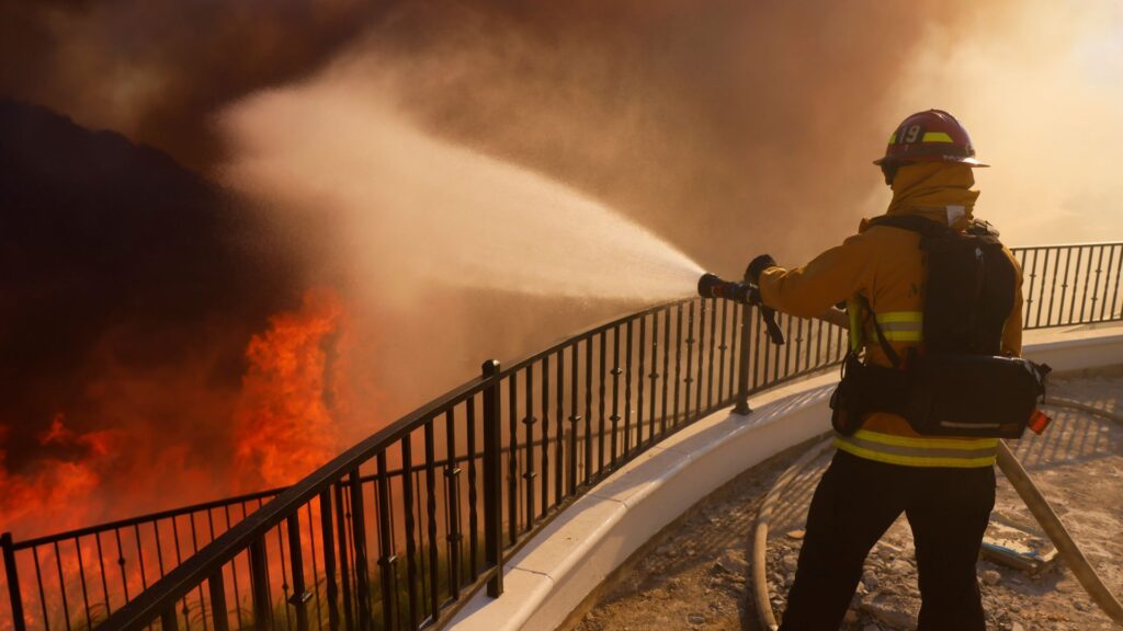 Film star helps firefighters battle LA wildfire sweeping exclusive hillside dotted with celebrity homes