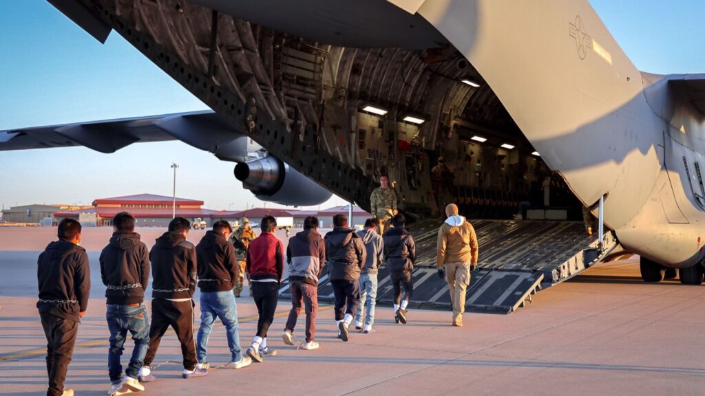 Men in shackles led on to US military plane as immigration arrests on rise