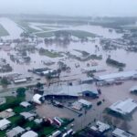 Woman dies and thousands urged to move to higher ground as ‘record-breaking rainfall’ hits Queensland