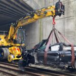 Car drives over bridge crashing onto rail line causing travel chaos